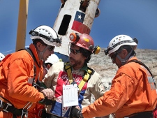 In this photo released by the Government of Chile, rescuers help miner Victor Segovia Rojas, center, after being rescued from the collapsed San Jose gold and copper mine, near Copiapo, Chile, Wednesday, Oct. 13, 2010. Segovia was the fifteenth of 33 miners rescued from the mine after more than 2 months trapped underground.(AP Photo/Hugo Infante, Government of Chile)