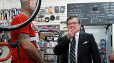 Jim Flaherty looks at bicycle after announcement