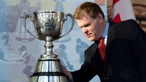 Minister of Foreign Affairs John Baird examines the Grey Cup before making a passport announcement at the Museum of History in Gatineau on Friday October 26, 2012. (The Canadian Press/Adrian Wyld)
