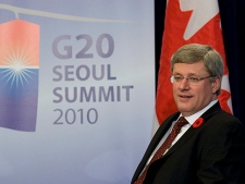 Prime Minister Stephen Harper waits for media to leave before starting a bi-lateral meeting with Australian Prime Minister Julia Gillard during a bilateral meeting at the G20 Summit in Seoul, Korea Thursday Nov. 11, 2010. (THE CANADIAN PRESS/Adrian Wyld)