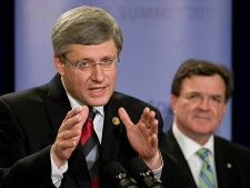 Minister of Finance Jim Flaherty looks on as Canadian Prime Minister Stephen Harper answers questions from the media following the G20 Summit in Seoul, Korea Friday Nov.12, 2010. (THE CANADIAN PRESS/Adrian Wyld)