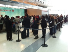 Dozens of people line up at the Air Canada ticket counter at Pearson International Airport to sort out their travel plans after massive delays were caused by a winter storm in Europe. (Aaron Adetuyi, CP24)