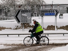 An airport worker makes his way out of London's Heathrow Terminal 5 on his bicycle,after all flights were cancelled due to the heavy snow, and vehicles had trouble reaching the airportSaturday Dec. 18, 2010.(AP Photo/Max Nash)