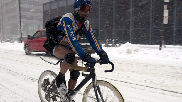 A bicycle courier wears shorts and ski goggles as he rides through a snow storm in downtown Toronto on Friday, Feb. 8, 2013. (Frank Gunn / THE CANADIAN PRESS)