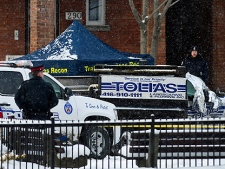 Police officers investigate the scene after they stopped a stolen snowplow and reportedly shot a suspect in Toronto on Wednesday, January 12, 2011. Earlier a Toronto police officer died after being struck by a stolen snowplow. (THE CANADIAN PRESS/Nathan Denette)