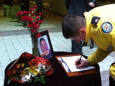 An unidentified officer signs a condolence book for Sgt. Ryan Russell at Toronto Police Services HQ on Thursday, Jan. 13, 2011. (CP24/Aaron Adetuyi)