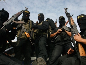 Masked Palestinian gunmen from the Islamic Jihad ride a on a vehicle during the funeral procession of Islamic Jihad militant, Mohammed al-Najjar, in the southern Gaza strip town of Khan Younis, Wednesday, Jan. 12, 2011. (AP Photo/Eyad Baba)
