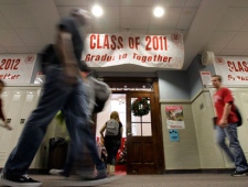 Students walk past a banner between classes at Richmond High School in Richmond, Ind., Monday, Nov. 29, 2010. The banners are signed by the students pledging to all graduate together. Named a dropout factory in 2007, the school worked with parents and the county's leaders to create tutoring programs for struggling students and encourage alternative classes such as dual enrollment where students earn both high school and college credit. (AP Photo/Darron Cummings)