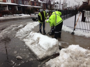 City of Toronto employees clear a drain that was clogged on Pape Avenue after a winter storm swept through the city Wednesday, Feb. 27, 2013. (Cam Woolley/CP24)