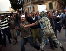 An Egyptian army soldier tries to stop anti-government protesters as they walk towards Tahrir Square in Cairo, Sunday, Jan. 30, 2011. The Arab world's most populous nation appeared to be swiftly moving closer to a point at which it either dissolves into widespread chaos or the military expands its presence and control of the streets. (AP Photo/Emilio Morenatti)