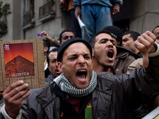 Egyptian anti-Mubarak protesters react as others, unseen, block the street to cut the access of public workers to the Mogama, the main government service building, in a street leading to Tahrir Square in Cairo, Egypt, Monday, Feb. 7, 2011. The protests, which saw tens of thousands of people massing daily in downtown Cairo for demonstrations that at times turned violent, have raised questions about the impact on the economy. More than 160,000 foreign tourists fled the country in a matter of days last week, in an exodus sure to hammer the vital tourism sector. (AP Photo/Emilio Morenatti)
