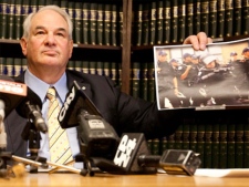 Lawyer Clayton Ruby, holding a picture of a police officer firing rubber bullets, calls for criminal investigation during a press conference on Friday, Feb. 11, 2011. (Darren Calabrese / THE CANADIAN PRESS)