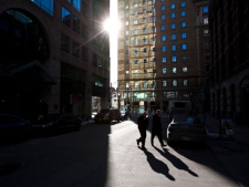 Pedestrians make their way through the shadows in Toronto's financial district on Tuesday, Feb. 15, 2011. (THE CANADIAN PRESS/Darren Calabrese)
