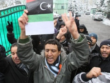 A Libyan citizen in Serbia waving an old Libyan flag during a protest against Moammar Gadhafi in front of the embassy in Belgrade, Serbia, on Tuesday, Feb. 22. 2011. (AP / Darko Vojinovic)