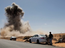 Smoke raises following an air strike by Libyan warplanes near a checkpoint near to the anti-Libyan Leader Moammar Gadhafi rebels checkpoint in the oil town of Ras Lanouf, eastern Libya, Monday, March 7, 2011. (AP Photo/Hussein Malla)