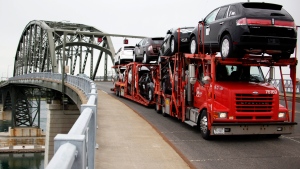 In this June 1, 2009 file photo, a truck loaded with Ford and Lincoln vehicles travels from Canada to the U.S. Peace Bridge border crossing in Buffalo, N.Y. (AP / David Duprey)