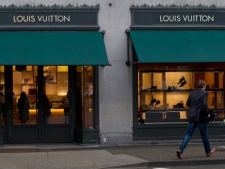A pedestrian runs past a Louis Vuitton store in downtown Vancouver, B.C. on Tuesday, March 8, 2011. A lawyer for the haute fashion house Louis Vuitton wants three accused Canadian counterfeiters to pay up to a million dollars in damages for peddling imposter goods. (THE CANADIAN PRESS/Jonathan Hayward)