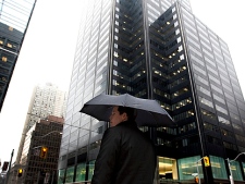 A man hides under an umbrella while walking in downtown Toronto Thursday, March 10, 2011.  (THE CANADIAN PRESS/Darren Calabrese)