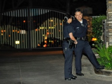 Los Angeles police officers wait outside actor Charlie Sheen's Sherman Oaks home in Los Angeles while other LAPD officer execute a search warrant for weapons, Thursday, March 10, 2011. No weapons were allegedly found. (AP Photo/Gus Ruelas)