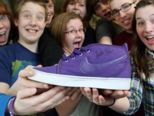 The communications club holds an autographed Justin Bieber running shoe at Bieber's former school, Northwestern Secondary School, in Stratford, Ont., Wednesday, March 9, 2011. The running shoe was auctioned on eBay as a school club fundraiser. (THE CANADIAN PRESS/Dave Chidley)