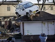A man snaps a picture of the aftermath of tsunami following Friday's massive tsunami triggered by a powerful earthquake in Sendai, Miyagi prefecture, northernJapan, Saturday, March 12, 2011