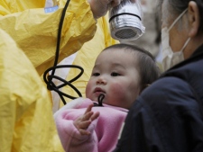 A baby is checked for radiation exposure level in Nihonmatsu in Fukushima prefecture (state) Tuesday, March 15, 2011 following a third explosion at the Fukushima Dai-ichi nuclear power complex Tuesday, March 15, 2011. (AP Photo/Kyodo News) 