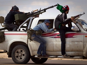 Libyan rebels retreat as mortars from Moammar Gadhafi's forces are fired on them on the frontline of the outskirts of the city of Ajdabiya, south of Benghazi, eastern Libya, Tuesday, March 22, 2011. (AP Photo/Anja Niedringhaus)