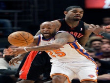 New York Knicks' Anthony Carter (25) attempts to break up a pass by Toronto Raptors' Amir Johnson, right, during the first half of an NBA basketball game Tuesday, April 5, 2011, in New York. (AP Photo/Frank Franklin II)