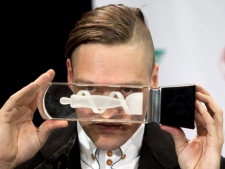 Arcade Fire lead singer Win Butler looks through one of the band's awards at the 2011 JUNO Awards in Toronto on Sunday, March 27, 2011. (THE CANADIAN PRESS/Darren Calabrese)
