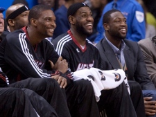 Miami Heat's, from left to right, Chris Bosh, LeBron James, and Dwyane Wade laugh while sitting on the bench during first half NBA basketball action against the Toronto Raptors in Toronto Wednesday, April 13, 2011. (THE CANADIAN PRESS/Darren Calabrese)