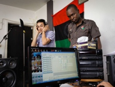 In this photo taken Tuesday, April 19, 2011, Mohammed Madani, a.k.a. Madani Lion, 22, left, and Milad Faraway, a.k.a. Dark Man, 20, right, of the Music Masters rap group listen as a sound engineer plays back their vocals during a recording session in Benghazi, Libya. (AP Photo/Ben Curtis)