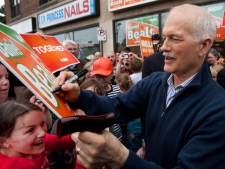 NDP Leader Jack Layton signs a poster for a young girl during a campaign stop in Kingston, Ont. on Sunday, May 1, 2011. The federal election will be held on May 2. (THE CANADIAN PRESS/Andrew Vaughan)