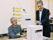 Liberal leader Michael Ignatieff, right, places his vote at an certified election Canada polling station in Etobicoke, Ont., on Monday, May 2, 2011. (THE CANADIAN PRESS/POOL/Mike Cassese)