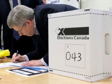 Prime Minister Stephen Harper signs a form as he casts his ballot in Calgary, Alta., Monday May 2, 2011. (THE CANADIAN PRESS/Adrian Wyld)