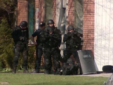 Police are seen outside an Alice Street address in Guelph, Ont., on Saturday, April 30, 2011.