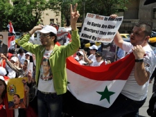 In this photo released by the Syrian official news agency SANA, Syrian pro-government supporters carry pictures of Syrian President Bashar Assad during a sit-in in front of the U.S. Embassy in Damascus, Syria, Wednesday, May 11, 2011. SANA said hundreds of Syrians held a demonstration Wednesday in front of the U.S. Embassy in Damascus to protest "U.S. intervention in the country's internal affairs." (AP Photo/SANA)