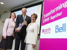 Darrell Gregersen, left, President and CEO of the Centre for Addiction and Mental Health Foundation, and Dr. Catherine Zahn, right, President and CEO of CAMH, present George Cope, President and CEO of Bell and BCE Inc., with a hand-blown hourglass containing crushed brick from a torn-down CAMH building, Wednesday, May 11, 2011, in Toronto. Bell's $10 million gift is the largest corporate donation to mental health in Canada, bringing CAMH's Transforming Lives Campaign to a historic high of $108 million. (The Canadian Press Images PHOTO/CAMH Foundation)