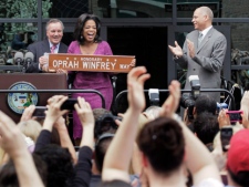 In this photo taken May 11, 2011, fans applaud as talk-show host Oprah Winfrey is honored with a street named for her outside her Harpo Studios in Chicago by Chicago Mayor Richard M. Daley, left, and Bobby Ware, commissioner of the Chicago Department of Transportation. Winfrey's talk show, which has taped in Chicago for 25 years, ends May 25, 2011. (AP Photo/M. Spencer Green)