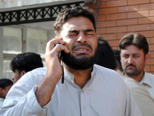 A man, who lost his family member in twin suicide bombs attacks, reacts as he talks on a phone in Peshawar, Pakistan on Friday, May 13, 2011. Twin explosions struck a paramilitary training center in northwestern Pakistan on Friday, in the bloodiest attack in the country since a U.S. raid killed al-Qaida chief Osama bin Laden. (AP Photo/Mohammad Zubair)