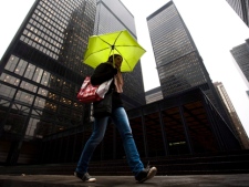 A pedestrian shields herself from rain under an umbrella in downtown Toronto on Friday, March 4, 2011. (THE CANADIAN PRESS/Darren Calabrese)