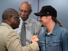Detroit Mayor Dave Bing, center, watches as Kid Rock greets Detroit NAACP President Wendell Anthony in the mayor's conference room in Detroit, Monday, May 16, 2011. Rock donated a total of $50,000 Monday to five charities in the Detroit area, fulfilling a promise to support his hometown. (AP Photo/Carlos Osorio)