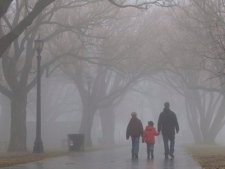 A family walks through fog along the lakeshore in Toronto in this Saturday, Jan. 1, 2011, file photo.(THE CANADIAN PRESS/Darren Calabrese)
