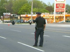 A police officer surveys the scene of a hit and run in Mississauga that sent a gas station attendant to hospital in critical condition Thursday, May 19, 2011.