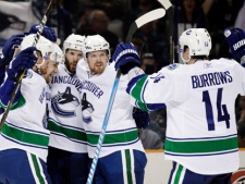 Vancouver Canucks center Ryan Kesler, center, is mobbed by teammates after his goal against the San Jose Sharks during the second period of Game 4 of the NHL hockey Stanley Cup playoffs Western Conference finals in San Jose, Calif., Sunday, May 22, 2011. (AP Photo/Marcio Jose Sanchez)