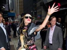 Lady Gaga tosses rose petals at photographers as she arrives for a taping of the "Late Show with David Letterman" in New York, Monday, May 23, 2011. (AP Photo/Charles Sykes)