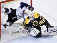Boston Bruins goalie Tim Thomas, right, makes a save as Tampa Bay Lightning center Steven Stamkos ends up airborne as he is checked into the goal during the first period of Game 5 of the NHL hockey Stanley Cup playoffs Eastern Conference finals, in Boston on Monday, May 23, 2011. (AP Photo/Charles Krupa)
