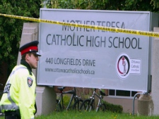 A policeman stands guard at the scene outside Mother Teresa Catholic School in Ottawa, Thursday May 26 2011. An 18-year-old student has been seriously injured in an explosion at a suburban Ottawa high school. (THE CANADIAN PRESS/Fred Chartrand)