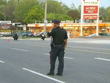 A police officer surveys the scene of a gas robbery in Mississauga that sent an attendant to hospital in critical condition, Friday, May 20, 2011.