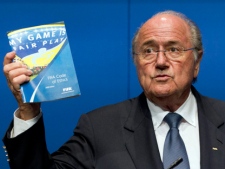 FIFA President Joseph S. Blatter holds the FIFA Code of Ethics while talking to the media during a press conference in Zurich, Switzerland, Monday, May 30, 2011. FIFA President Sepp Blatter says "great damage" has been done to world football's governing body by bribery allegations against two senior executive committee members but insisted there was no problem with awarding the 2022 World Cup to Qatar. (AP Photo/Keystone/Alessandro Della Bella)