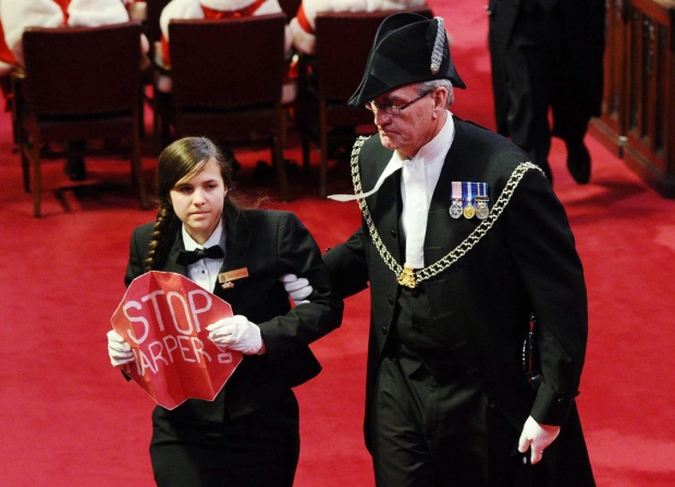 Sergeant at Arms Kevin Vickers escorts a protester from the floor of the Senate as Governor General David Johnston delivers the Speech from the Throne on Parliament Hill in Ottawa, Friday June 3, 2011. (THE CANADIAN PRESS/Sean Kilpatrick)